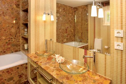 a bathroom with two sinks and a tub at Pine Cliffs Village in Albufeira