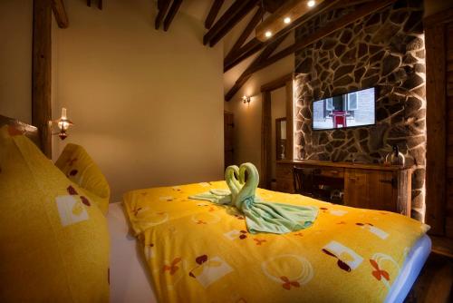 a bedroom with a bed with a yellow bedspread with a frog on it at Chata Piecky in Hrabušice