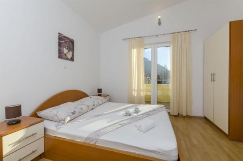 a bedroom with a bed and a window at Apartments Srecko in Duće