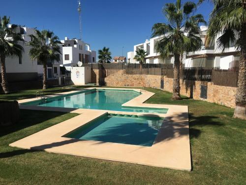 a swimming pool in a yard with palm trees at Casa Mordi in Villamartin