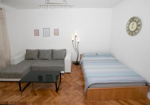 een slaapkamer met 2 bedden en een klok aan de muur bij Downtown 3 Bedroom Apartment in Sarajevo