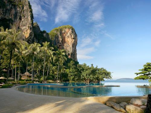 a view of a beach with palm trees and a mountain at Rayavadee in Railay Beach