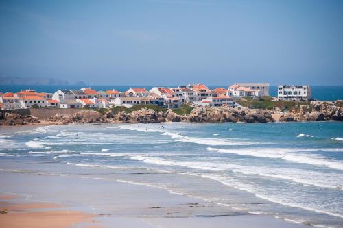 Una vista de una playa con casas y el océano. en Fabulous Beach House on the Atlantic, en Baleal