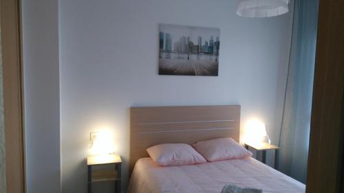 1 dormitorio con 1 cama con 2 almohadas y 2 luces en Apartamento a 150m de la playa en Torrevieja en Torrevieja