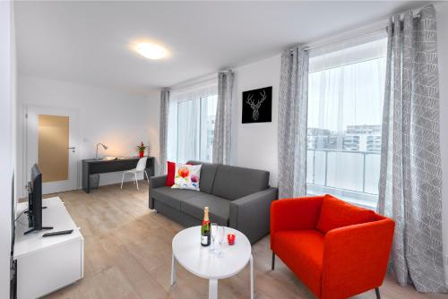 a living room with a couch and a red chair at CityWest Apartments in Prague