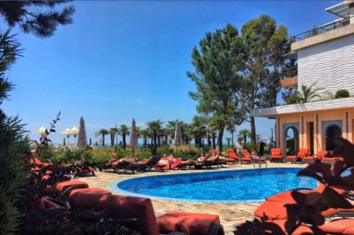 a swimming pool with lounge chairs next to a building at Ana's Apartment in Chakvi Oasis in Chakvi