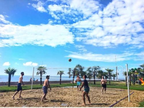 a group of people playing a game of volley ball on the beach at Ana's Apartment in Chakvi Oasis in Chakvi