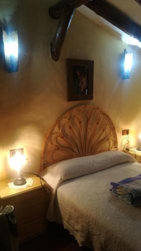 a bedroom with a large bed and two lamps at El Rinconcito in Zahara de la Sierra