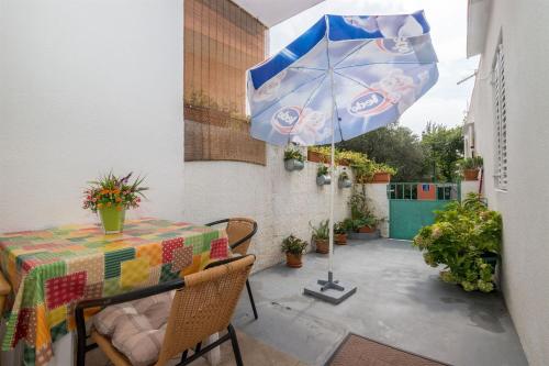 a patio with a table and an umbrella at Apartments Ante in Igrane