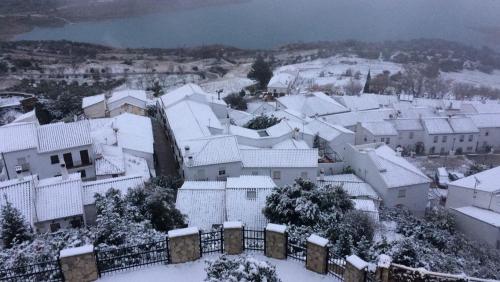 a snow covered city with houses and a fence at El Rinconcito in Zahara de la Sierra