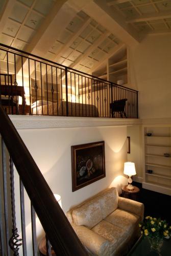 a living room with a couch and a staircase at Grand Hotel Plaza in Rome