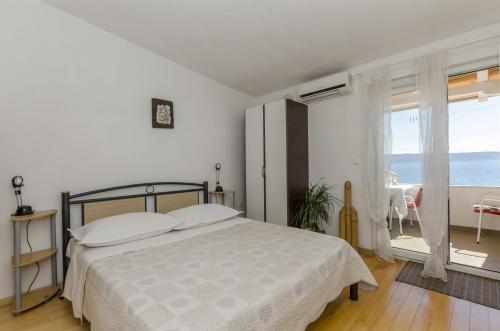 a bedroom with a bed and a view of the ocean at Apartments Zanet in Sumpetar