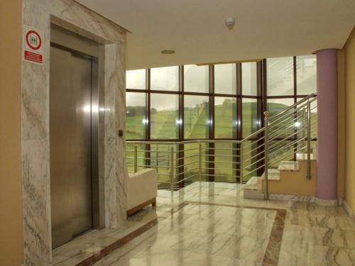 a lobby with a glass door and a large window at Hotel Royal in Llanera