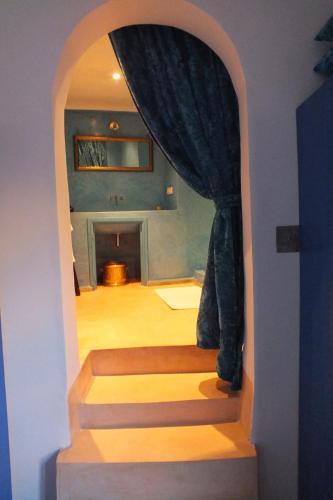 an archway leading to a room with a staircase with a curtain at Dar Faracha Fes in Fès