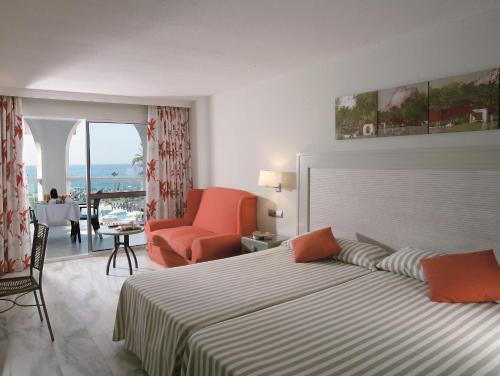 Habitación de hotel con cama y sala de estar. en Ona Marinas de Nerja Spa Resort en Nerja