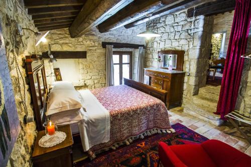 a bedroom with a bed and a stone wall at AGRITURISMO Case Catalano in Abbateggio
