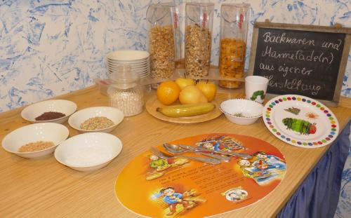 a table topped with bowls of food and a chalkboard at Hotel Villa Tummelchen in Cochem