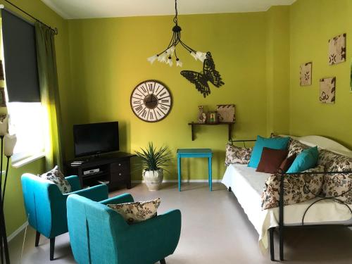 a living room with green walls and blue chairs at Ferienwohnungen Perlina Karpat in Bernkastel-Kues