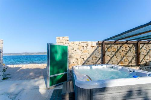 a tub on the beach with the ocean in the background at House Merica in Mali Drvenik