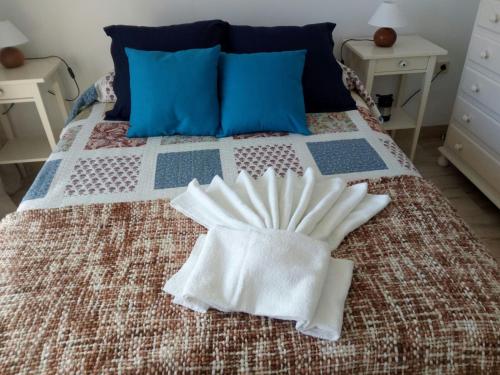 a bed with two white towels on top of it at Casa Cachita-En 1ª línea de playa in Estepona