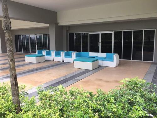 a lobby with blue and white benches in a building at Meridin Medini Muslim Condo in Nusajaya