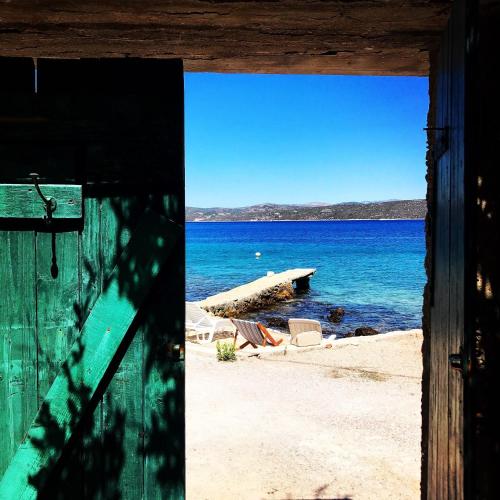 a view of a beach from an open door at House Mislav II in Velike Kuknjare