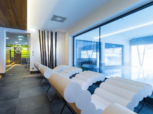 a conference room with white chairs and a large window at Alpinresort ValSaa - Sport & Spa in Saalbach Hinterglemm
