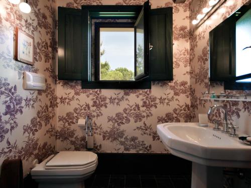 a bathroom with a toilet and a sink at La Casetta Sicilian Cottage in Case Rosolia