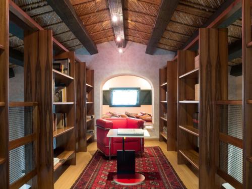 a living room with a red couch in a room with shelves at La Casetta Sicilian Cottage in Case Rosolia