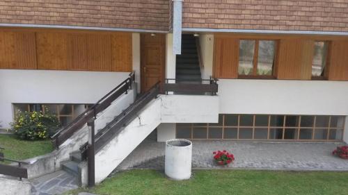 a house with a staircase and a porch with flowers at Casa Chigi in Valdidentro
