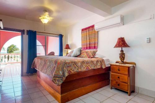 um quarto com uma cama e um candeeiro numa cómoda em Cacao @ Caribe Island em San Pedro