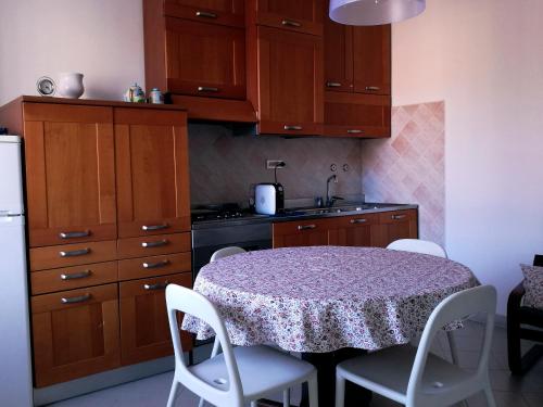 a kitchen with a table with white chairs and a sink at La Piazzetta in Sestri Levante