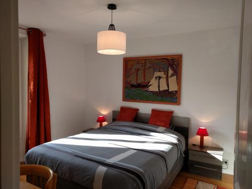 een slaapkamer met een bed met een schilderij aan de muur bij L'Orée de Versailles in Versailles