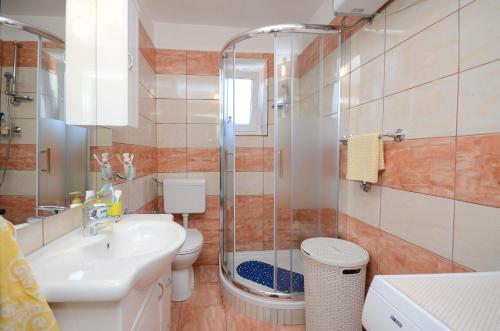 een badkamer met een toilet, een wastafel en een douche bij Apartment Milan in Senj
