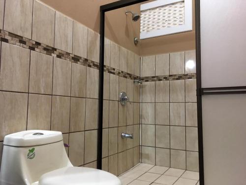 uma casa de banho com chuveiro e WC em Hotel Hacienda El Rodeo em Rodeo