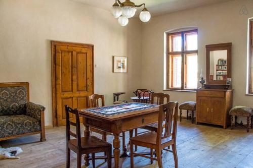 jadalnia z drewnianym stołem i krzesłami w obiekcie Casa Arthur Richis w mieście Richişu
