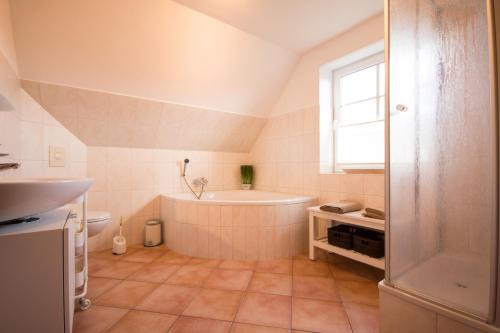 a bathroom with a bath tub and a window at Haus Lotte in Garding