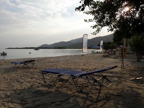 a picnic table on a beach next to the water at Hotel Prinos in Prinos