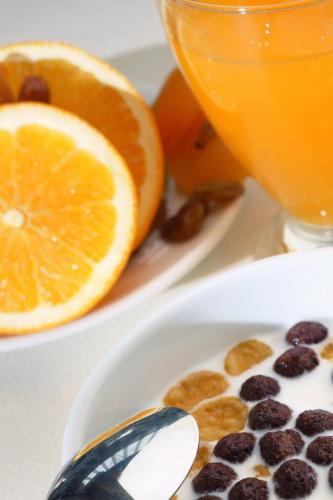 a plate of food with orange slices and a spoon at Hotel Helen Park in Canakkale