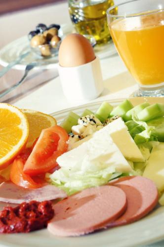 a plate of food with cheese and vegetables and an egg at Hotel Helen Park in Canakkale