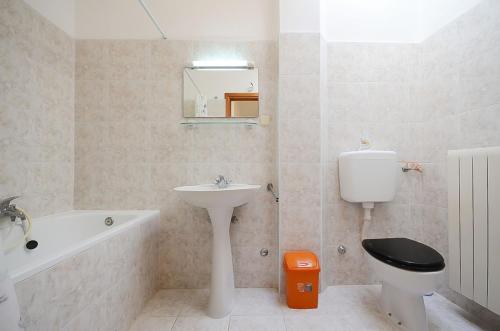 a bathroom with a sink and a toilet and a mirror at House Marija in Fažana