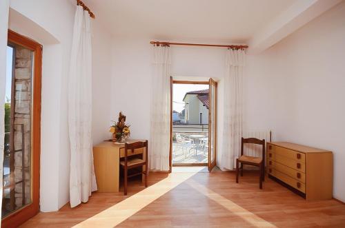 a room with a desk and a dresser and a window at House Marija in Fažana