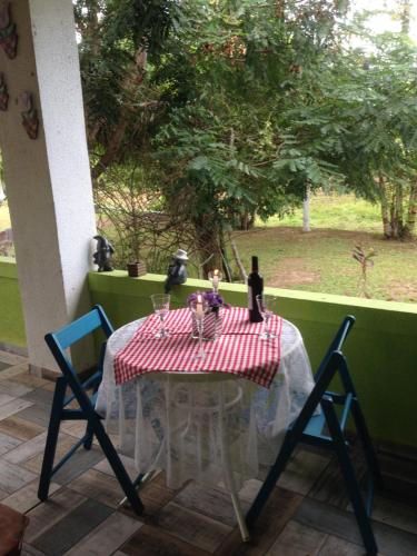uma mesa com uma toalha de mesa vermelha e branca e duas cadeiras em Sítio FWG em Camaçari