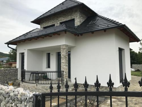 a white house with a black roof at Győri vendégház in Demjén