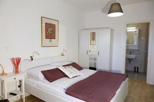 a white bed in a white bedroom with a sink at Central Apartments with Parking in Ljubljana