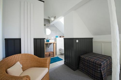 ein Wohnzimmer mit einem Sofa und einem Stuhl in einem Zimmer in der Unterkunft B&B De Hanewijkhoeve in Werchter