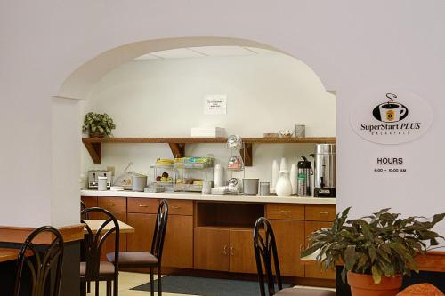 a kitchen with a table and chairs in a restaurant at Super 8 by Wyndham Manchester Airport in Manchester