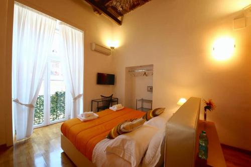 una camera da letto con un grande letto con una coperta arancione di Talismano Luxury Rooms & Apartments a Napoli