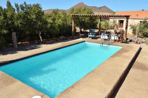 uma grande piscina azul com um gazebo em Agroturismo La Gayria em Tiscamanita