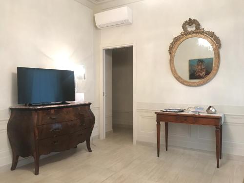 een kamer met een televisie op een dressoir en een spiegel bij La casa di Anna in Viareggio